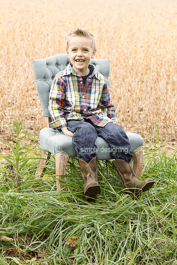 Full body Photo of Boy on an upholstered Chair in a field smiling