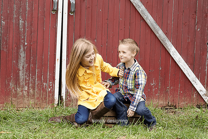 Candid photo of kids in front of red barn doors being silly