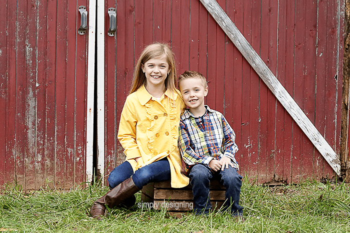 Kids sitting together on a Wooden Crate in front of barn doors