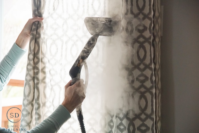 Using a HomeRight steam machine to get creases out of curtains while they are hanging on the curtain rod