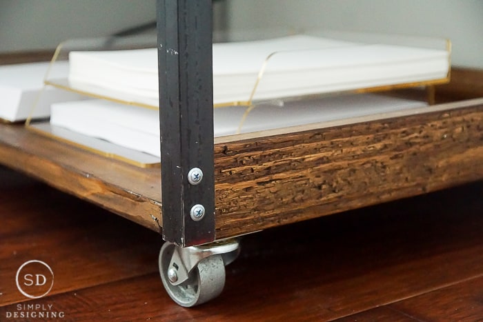 close up photo of wheels and bottom shelf of printer table cart