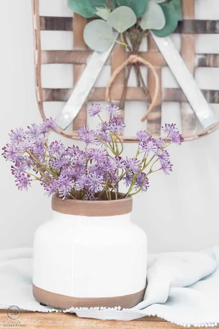 purple flowers in white ceramic vase