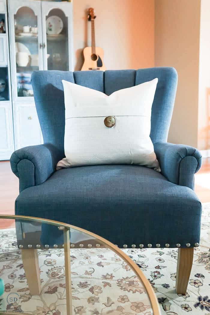 blue chair with cream pillows in front room makeover