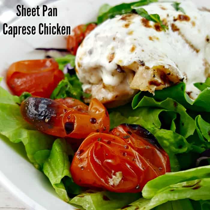 Sheet Pan Caprese Chicken - Mozzarella covered chicken on a bed of greens with blistered grape tomatoes