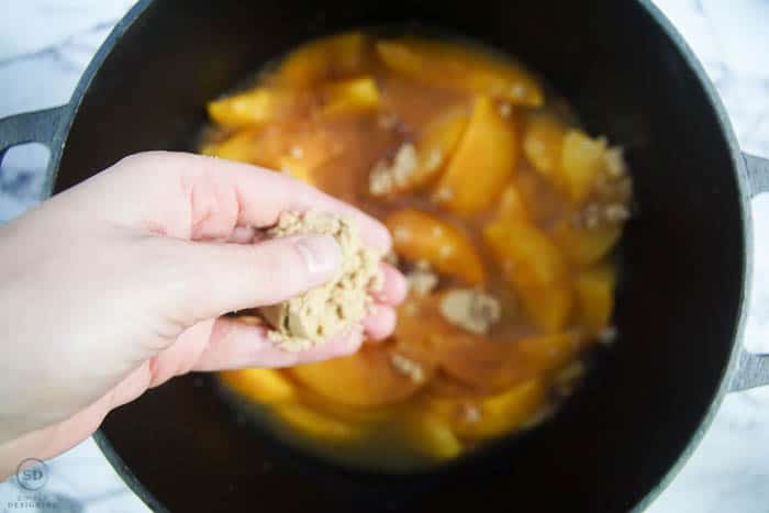 put brown sugar on top of peaches for dutch oven peach cobbler