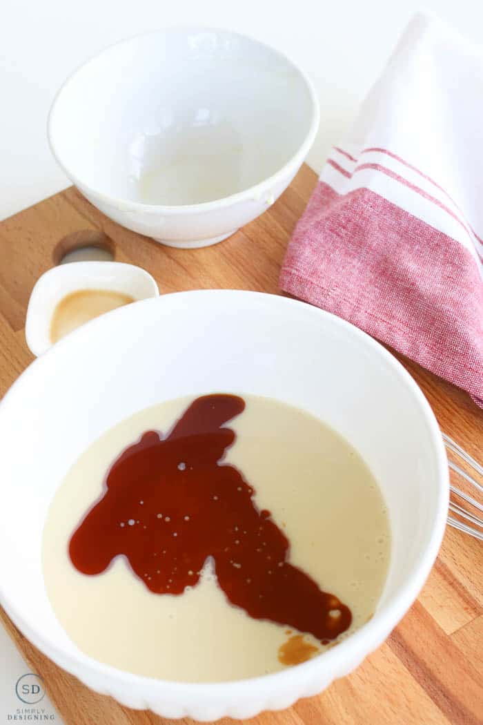 Adding sweetened condensed milk and vanilla extract to a bowl to make homemade ice cream.