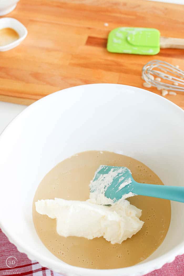 Folding whipped cream into other ingredients for ice cream.