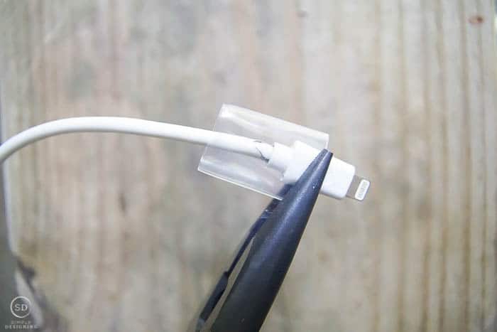 hold heat shrink tube on iPhone charger with pliers