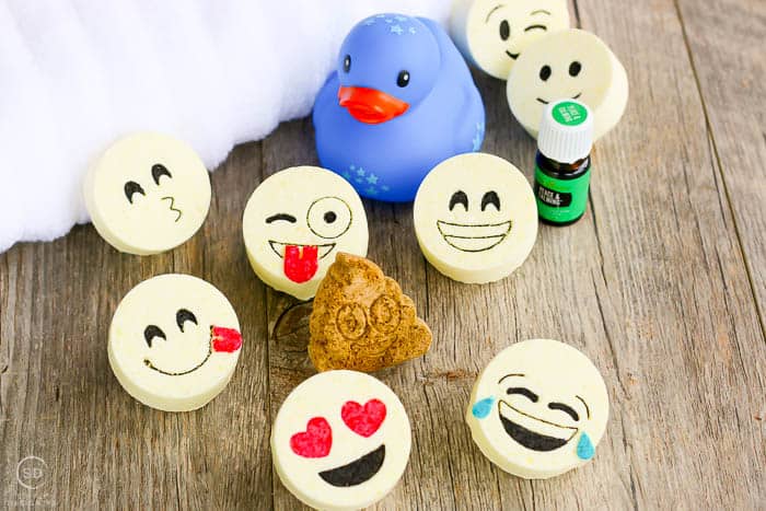 The final product of this bath bombs recipe are these adorable kids bath bombs with emoji faces. A fun show showing the completed bath bombs and other bath essentials. 