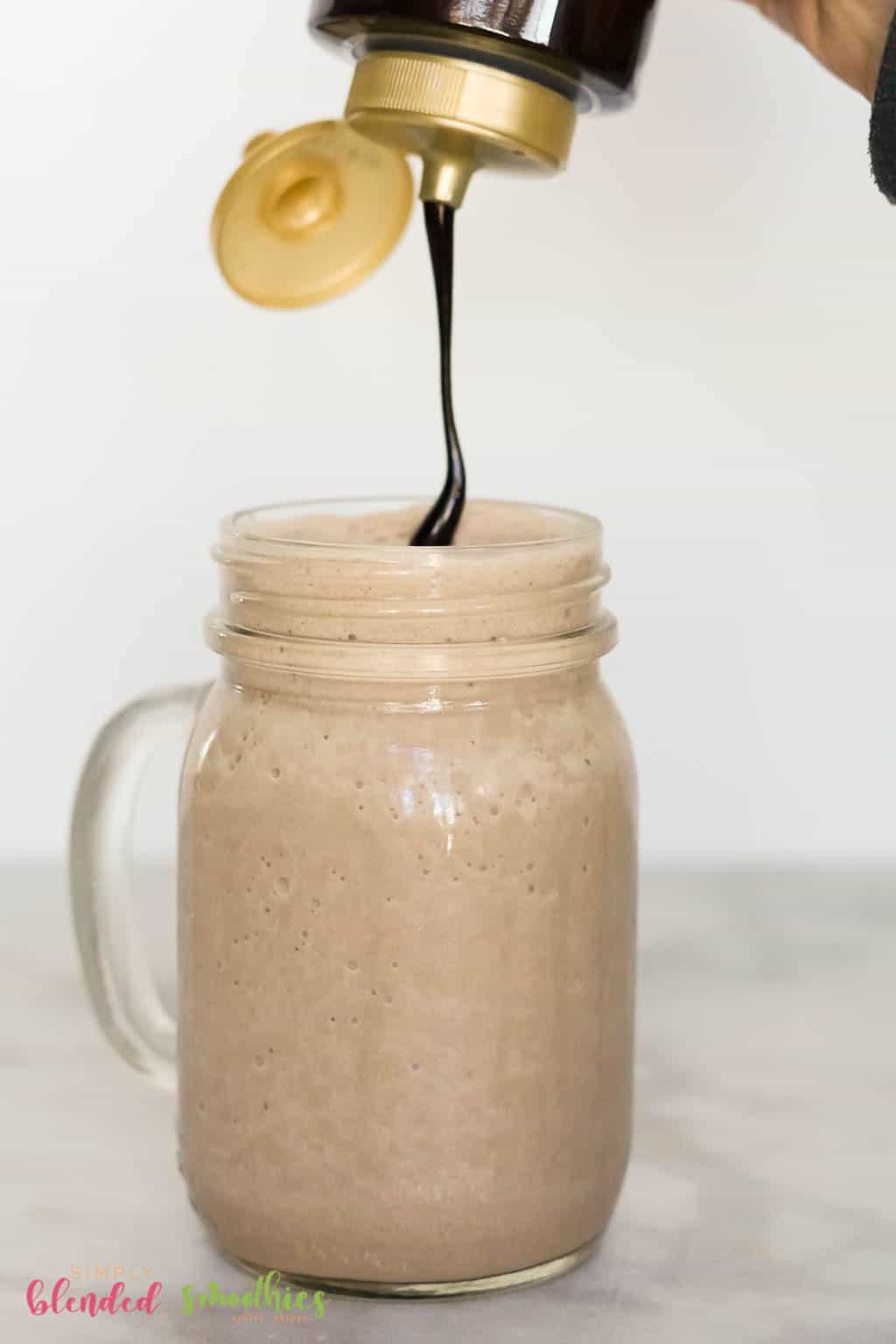 Chocolate Frappe 7 drizzling chocolate syrup on top of a chocolate frappuccino in a mason jar glass