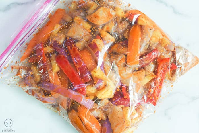 chicken sheet pan fajitas ingredients mixed in a ziploc bag