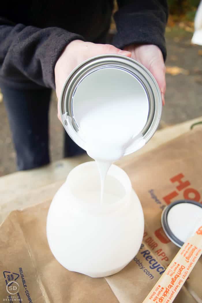 pour white paint in to paint sprayer