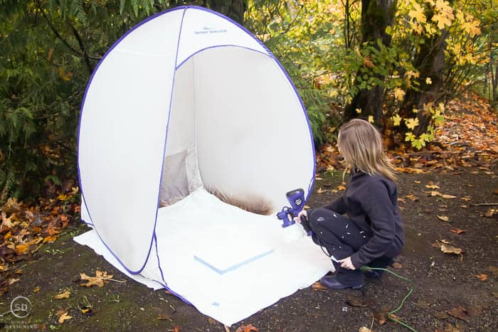 paint frame with a paint sprayer and white paint