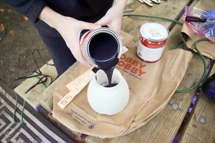 pour black paint into paint sprayer