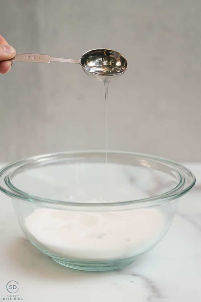pouring fractionated coconut oil into sugar for a sugar scrub