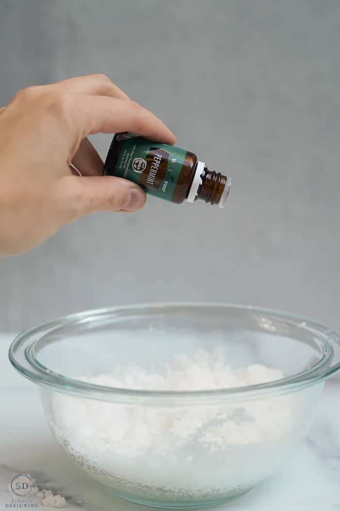 adding peppermint essential oil into sugar and oil mixture