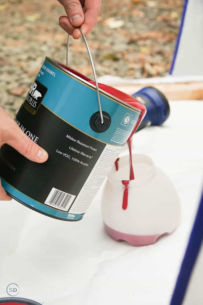 pour red paint into spray painter