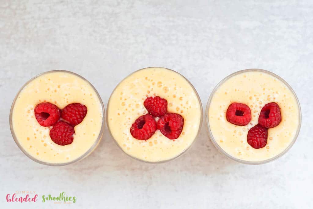 Banana Peach Smoothie 3 raspberries on top of a smoothie made with peaches