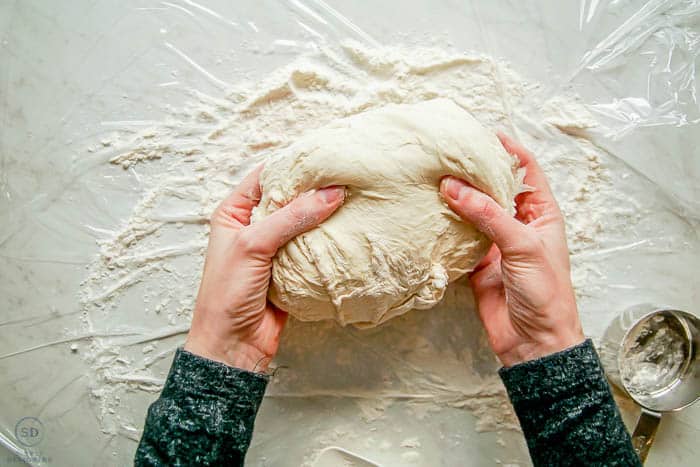 holding bread dough in two hands