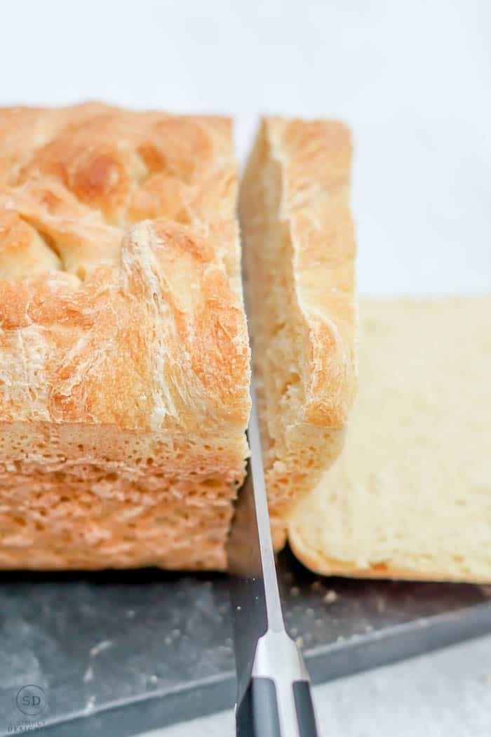 cutting into homemade bread loaf