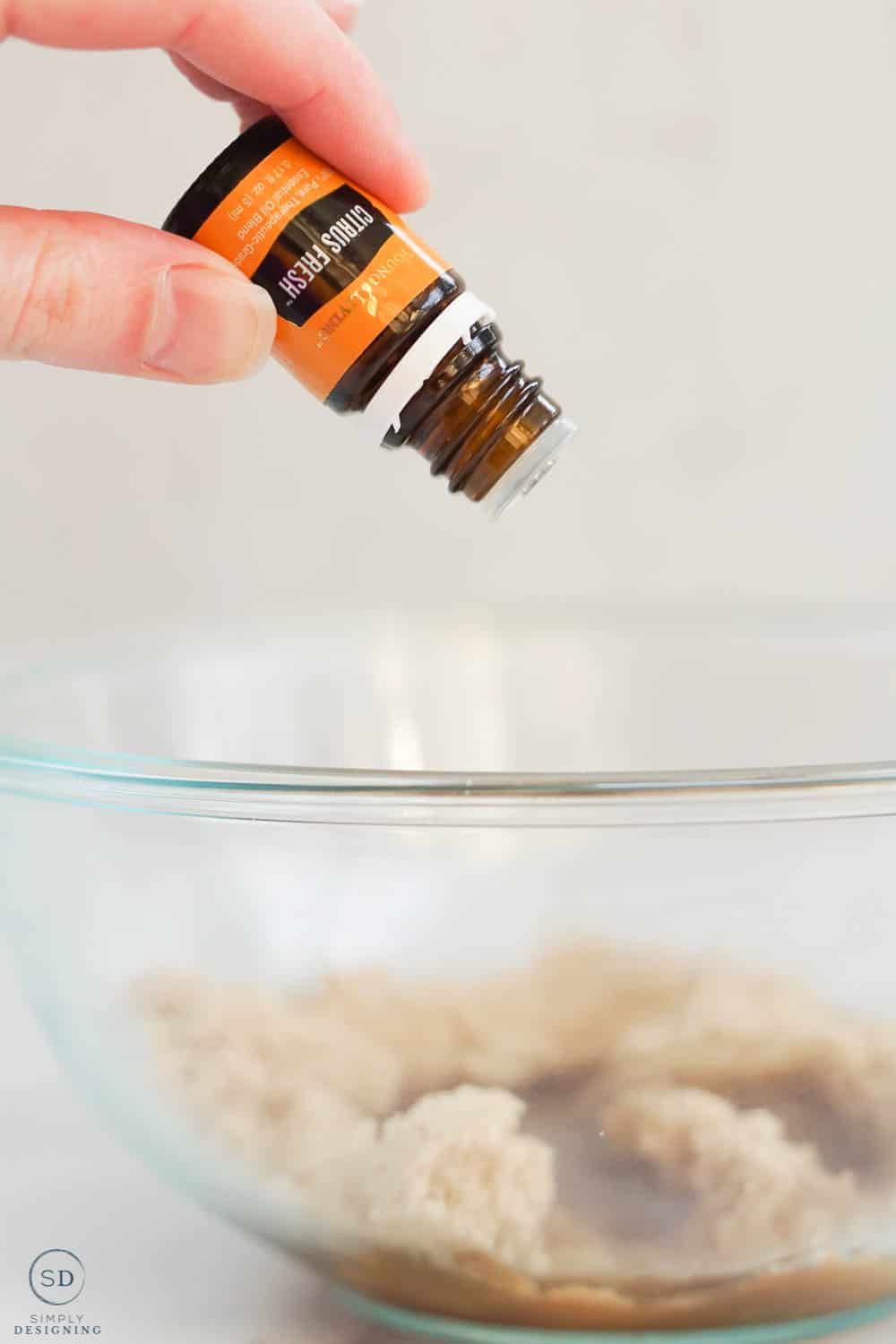 dropping drops of citrus fresh essential oil into bowl