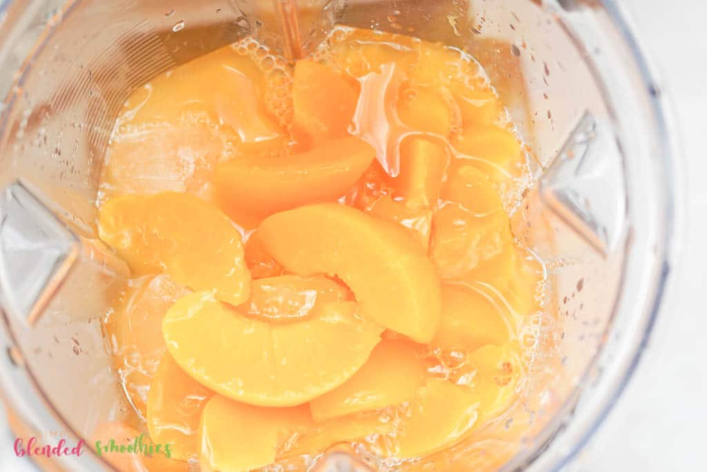 Mango Peach Smoothie 8 looking into the top of a blender with mangos and peaches in it