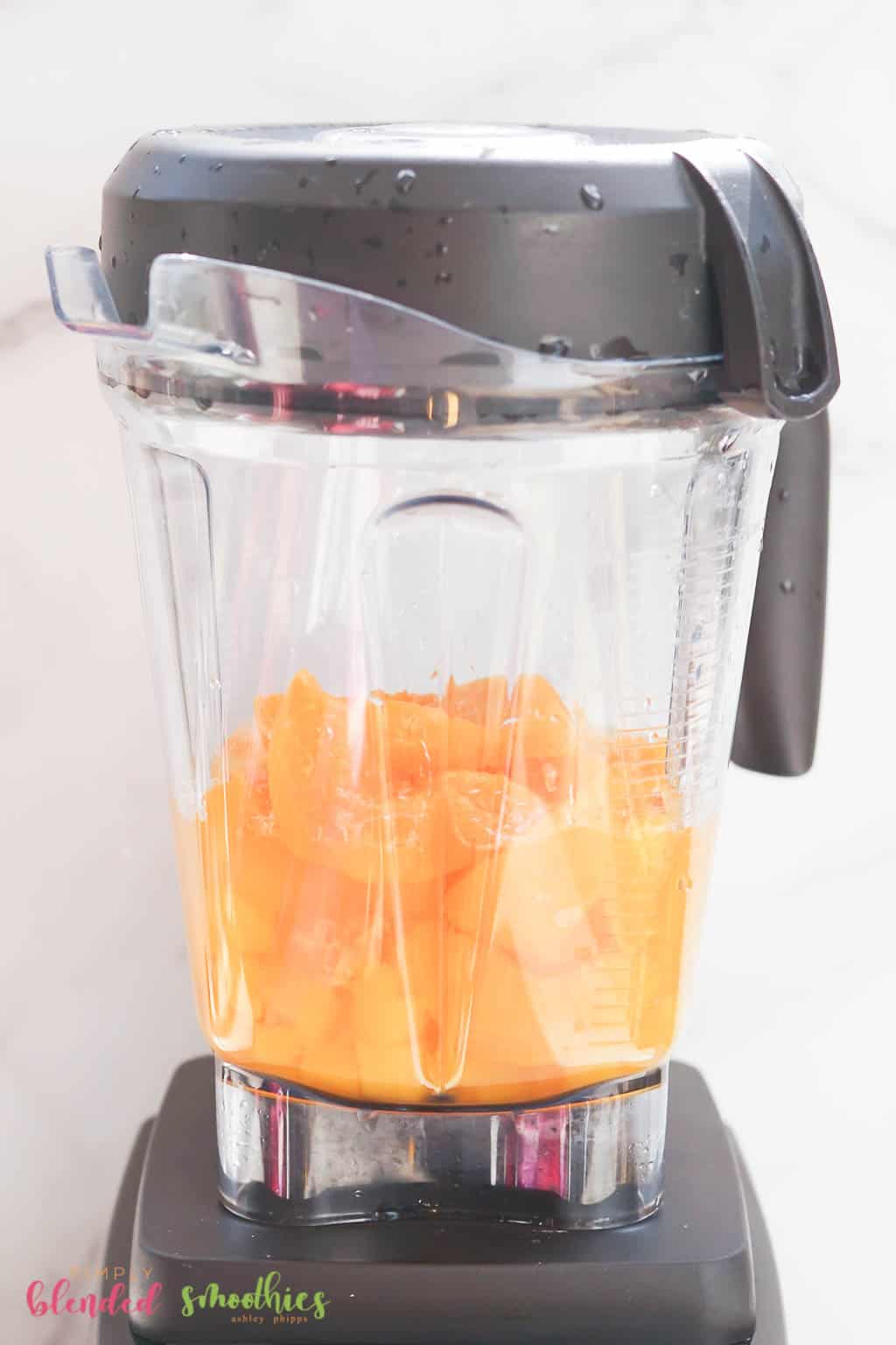 Mango Peach Smoothie 9 looking at the side of a blender with mangos and peaches in it