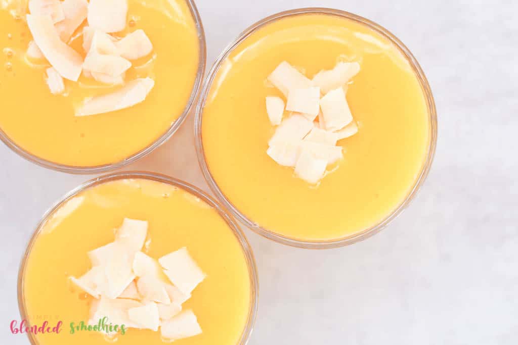 mango peach smoothie with coconut flakes looking from the top down