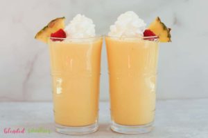 Peach Pineapple Milkshake 23 two pineapple peach milkshakes with whipped cream topping looking at them from the side in a horisontal photo