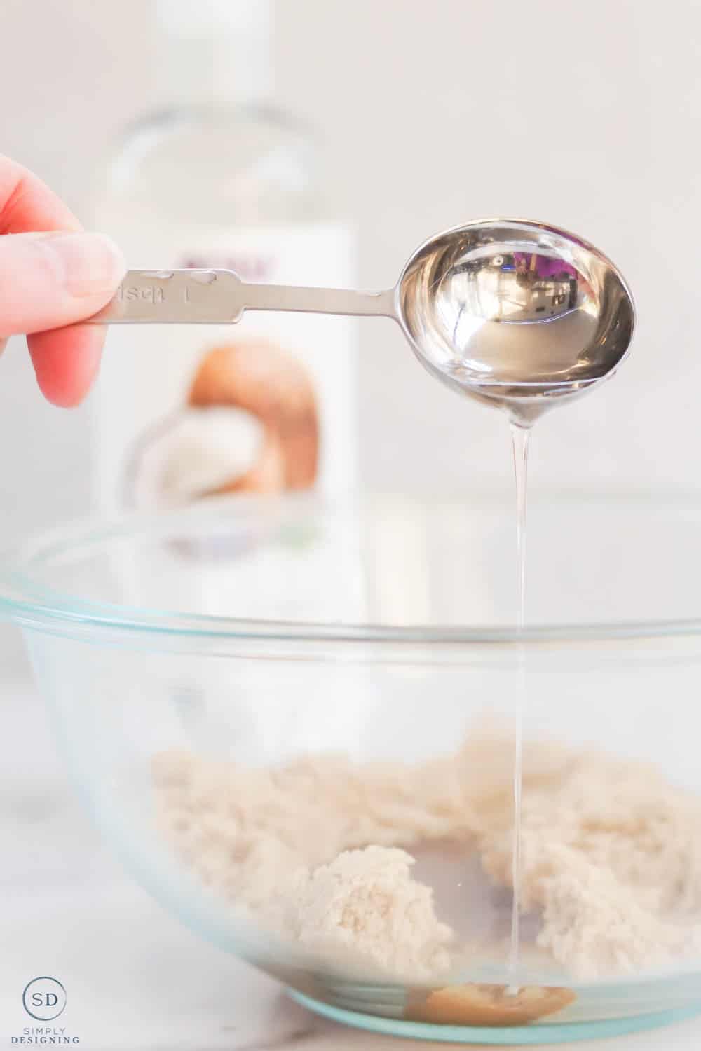 use measusing spoon to pour fractionated coconut oil into brown sugar