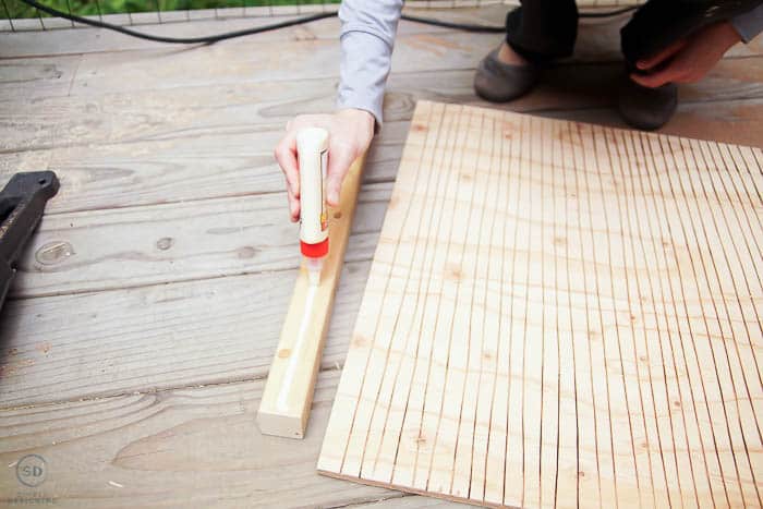 applying wood glue to board