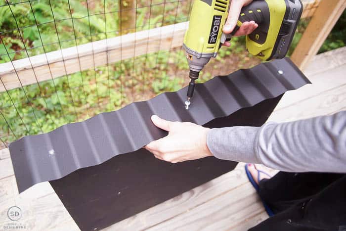 using drill to screw corrugated metal to roof for bat box