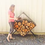 woman filling square firewood holder with firewood