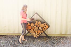 woman filling square firewood holder with firewood