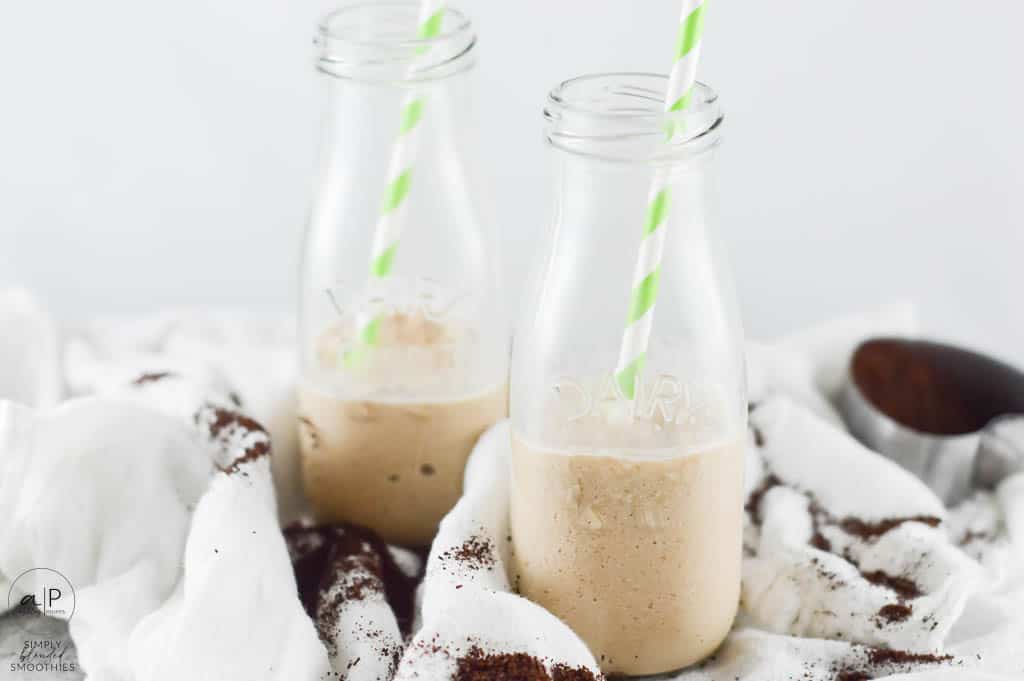 Coffee Smoothie 2 half full coffee smoothie in milk glasses with green and white straw